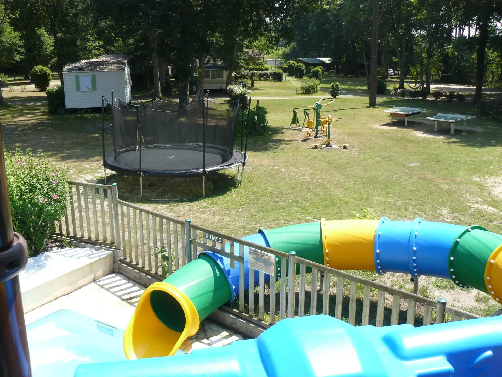 Toboggan aquatique coloré près de l’aire de loisirs arborée du camping à Saint-Justin